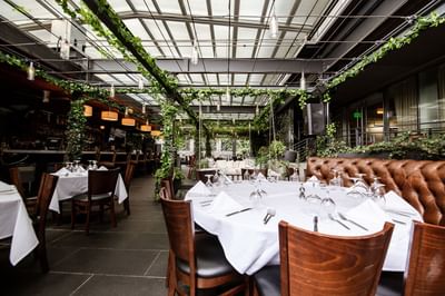 Dining area with warm ambiance in Tony's at J House Greenwich, a romantic hotel in Greenwich with fine dining restaurant