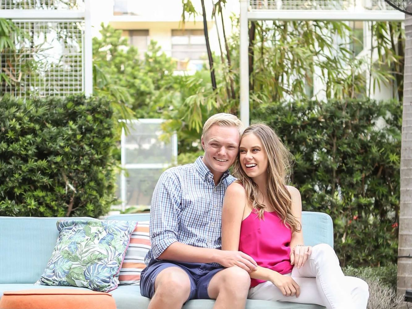 A couple posing for a picture outdoors on a cozy couch at Fairwind Hotel Miami