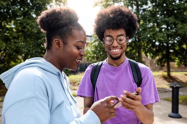 Women and man playing Pokémon go together outdoors