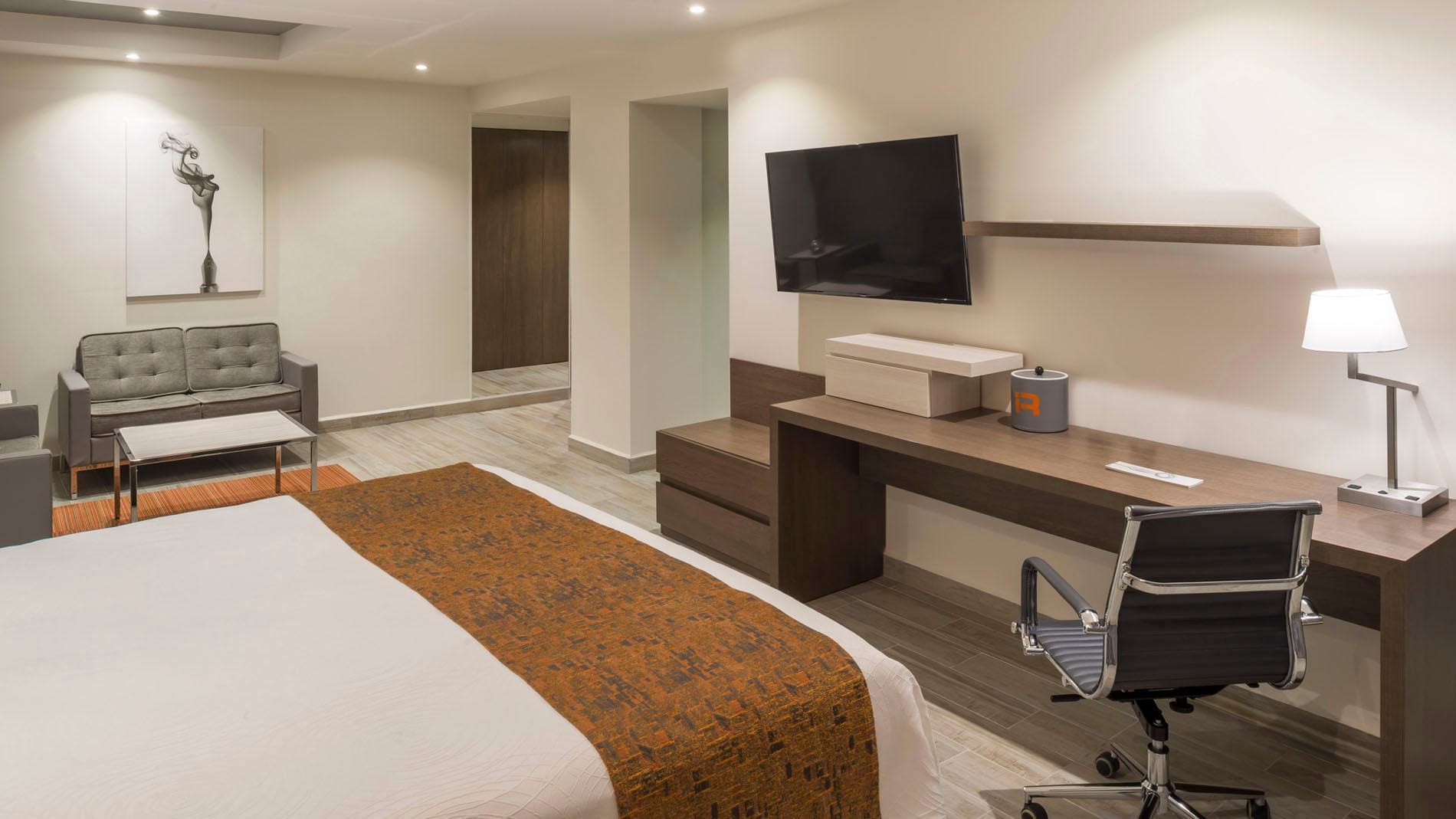 King Junior Suite with a wooden work desk, ergonomic chair, and wall-mounted flat screen at Real Inn Celaya