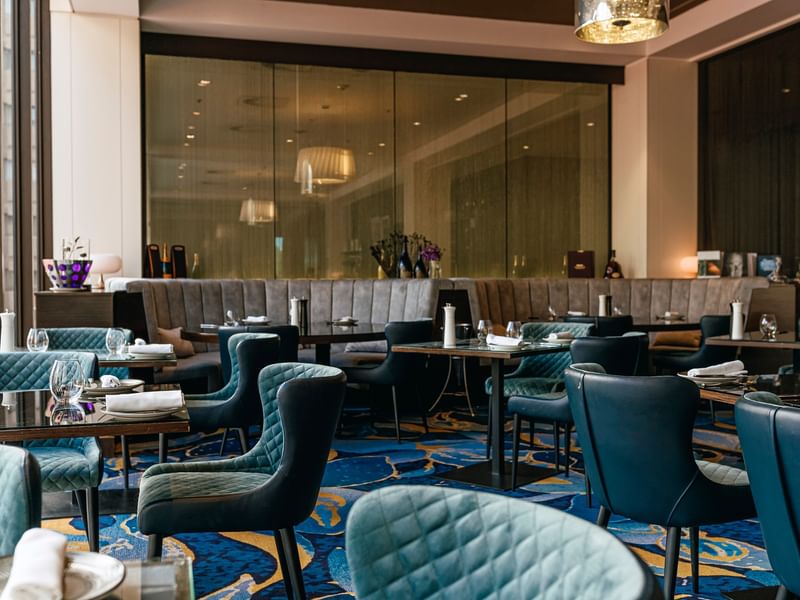PRIVÉ event room with teal quilted chairs, patterned blue carpet, and elegant banquette seating at Sofitel Brisbane Central.