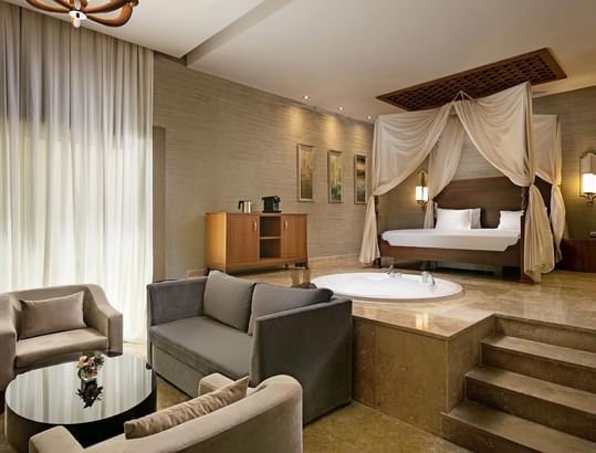 Ottoman Spa Suite with canopy bed, sitting area, and sunken bathtub at Titanic Deluxe Golf Belek