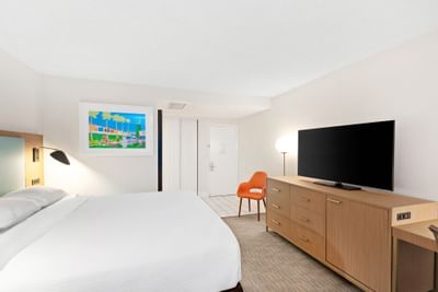 Comfy bed, TV, chair in King room at The Anaheim Hotel