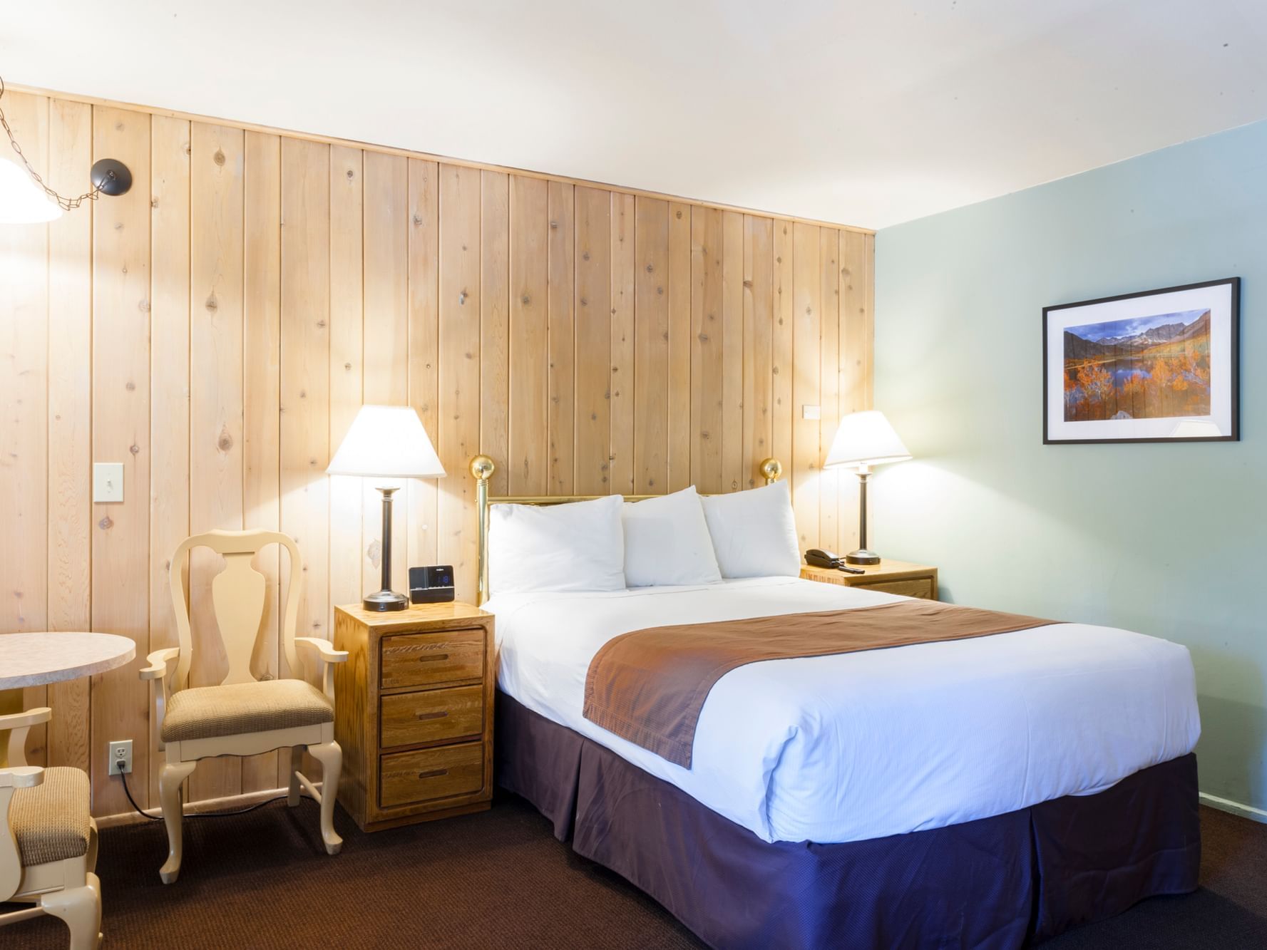 Comfy bed and lamps in Queen Fireplace Room at Alpenhof Lodge