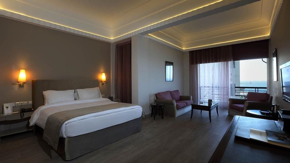 Cozy interior with wooden floors & city view in Senior Suite Bedroom at Warwick Palm Beach Hotel - Beirut