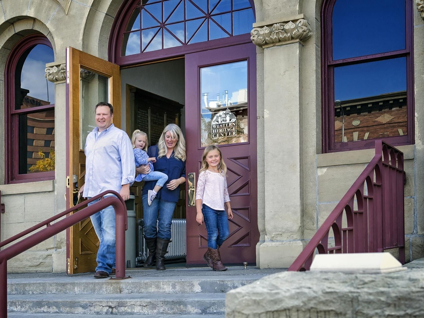 A family posing on the steps of Western Heritage Center near Boothill Inn & Suites