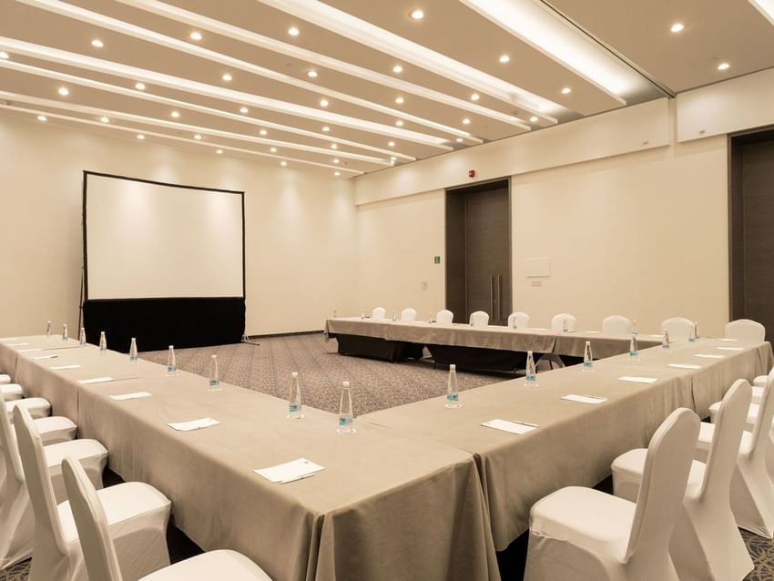 Niza room with U-shaped table setup and a large projection screen at Camino Real Fashion Drive, Monterrey