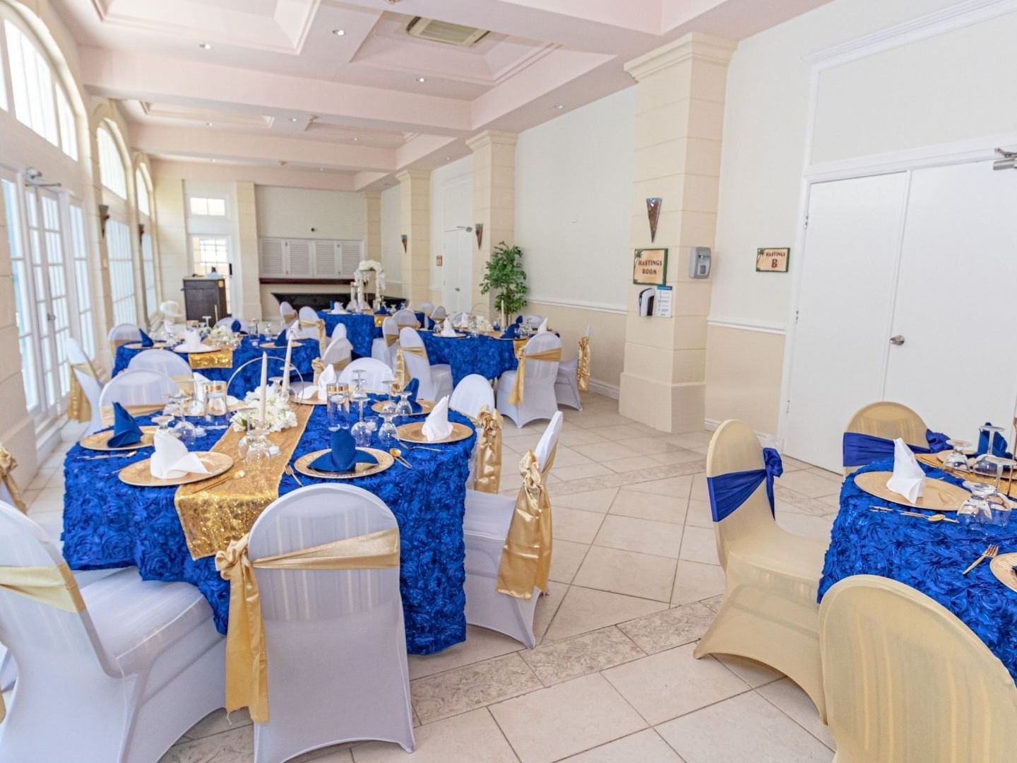 Elegantly decorated banquet hall with blue and gold tablecloths at Savannah Beach Hotel.