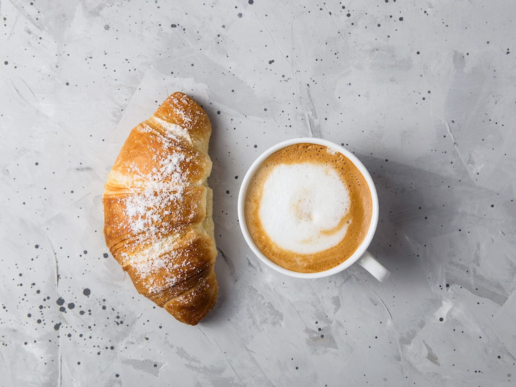 a cup of coffee and a croissant