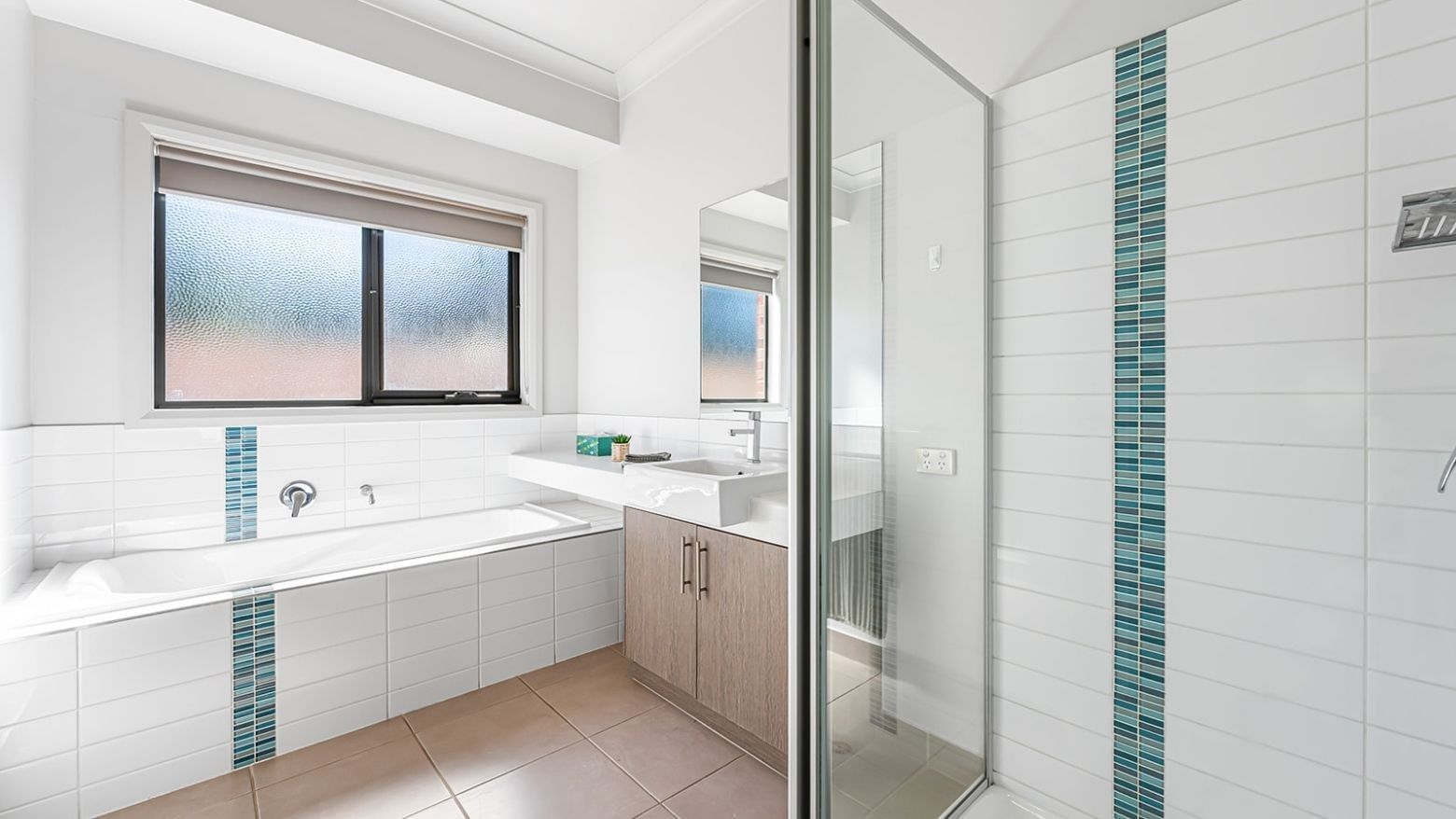 White bathroom with bathtub, sink, and shower at La Trobe University Regional Housing – Mildura.