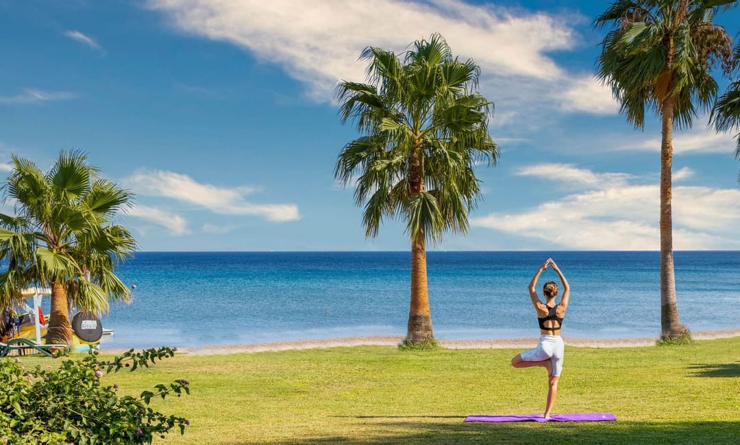Bodrum Imperial'de sahilde yoga yapan bir kadın