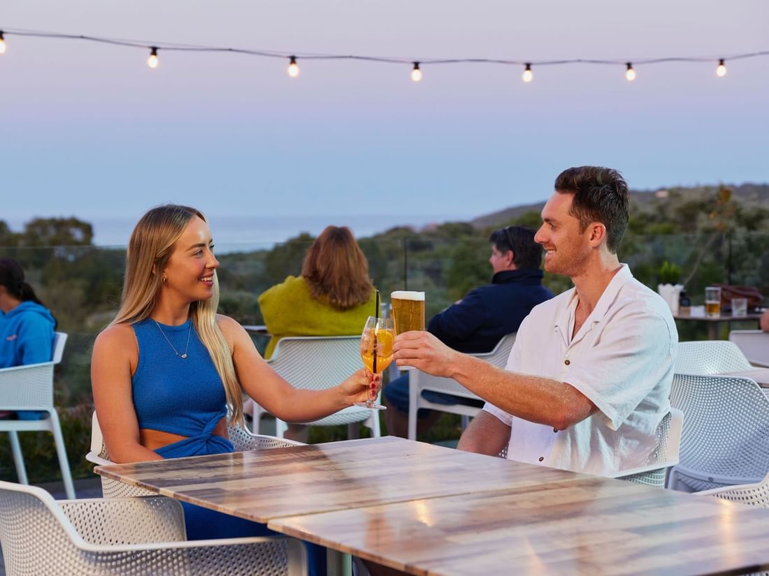 Couple drinking on balcony at sunset