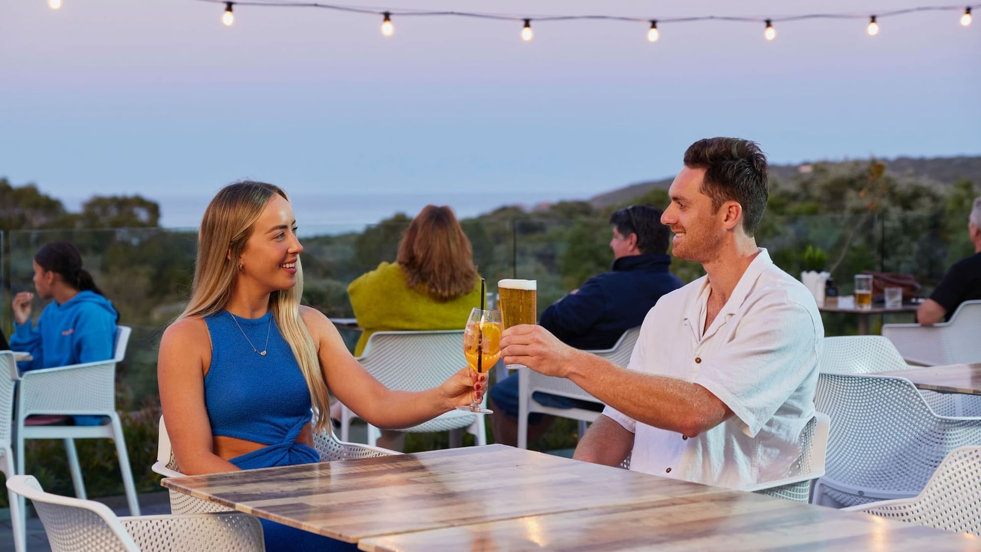 Couple drinking on balcony at sunset