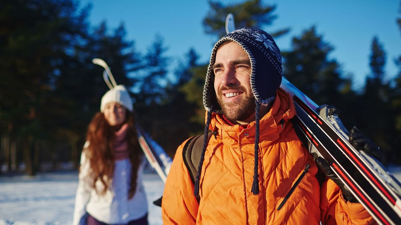 Two Skiers walking hold their skis