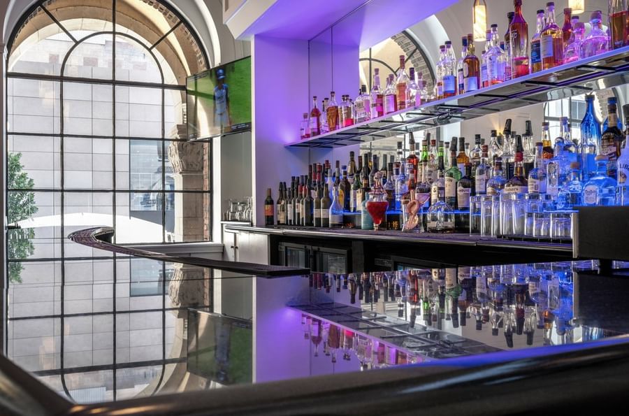 Shelves of liquor bottles by the bar counter in Allerton Hotel Lobby Lounge at Warwick Allerton Chicago