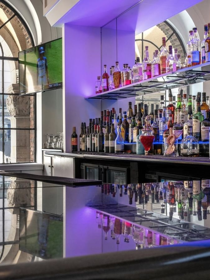 Shelves of liquor bottles by the bar counter in Allerton Hotel Lobby Lounge at Warwick Allerton Chicago