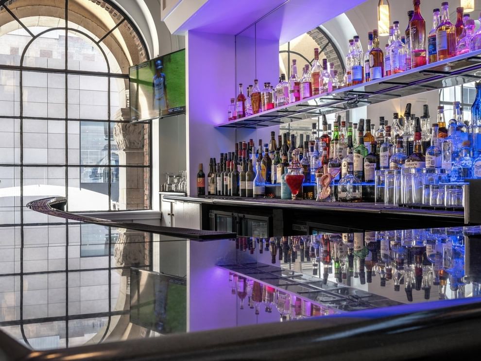 Shelves of liquor bottles by the bar counter in Allerton Hotel Lobby Lounge at Warwick Allerton Chicago