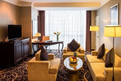 Living area with sofas & a TV in Club Executive Suite at Eastin Grand Hotel Saigon