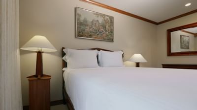 white bed in room with paintings