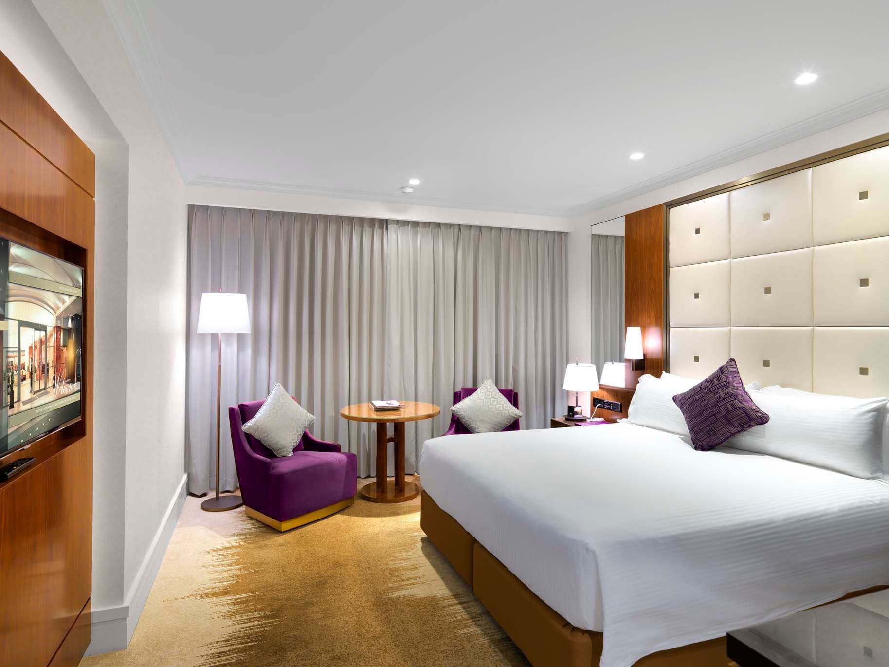 Bed & lounge in Deluxe Tower King Room at Amora Hotel Sydney