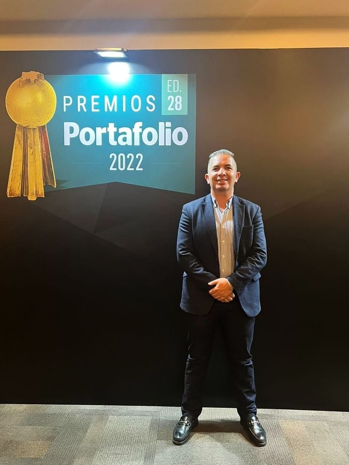 Man posing by Premios Portafolio Board at 3C Hotels