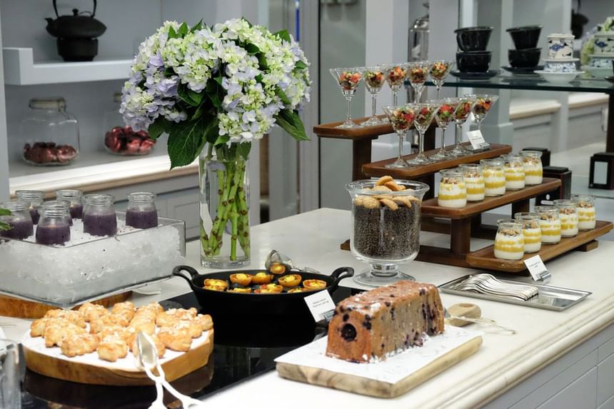 Elegant dessert display featuring floral arrangements, layered parfaits, pastries, and colorful treats at Park Hyatt Saigon