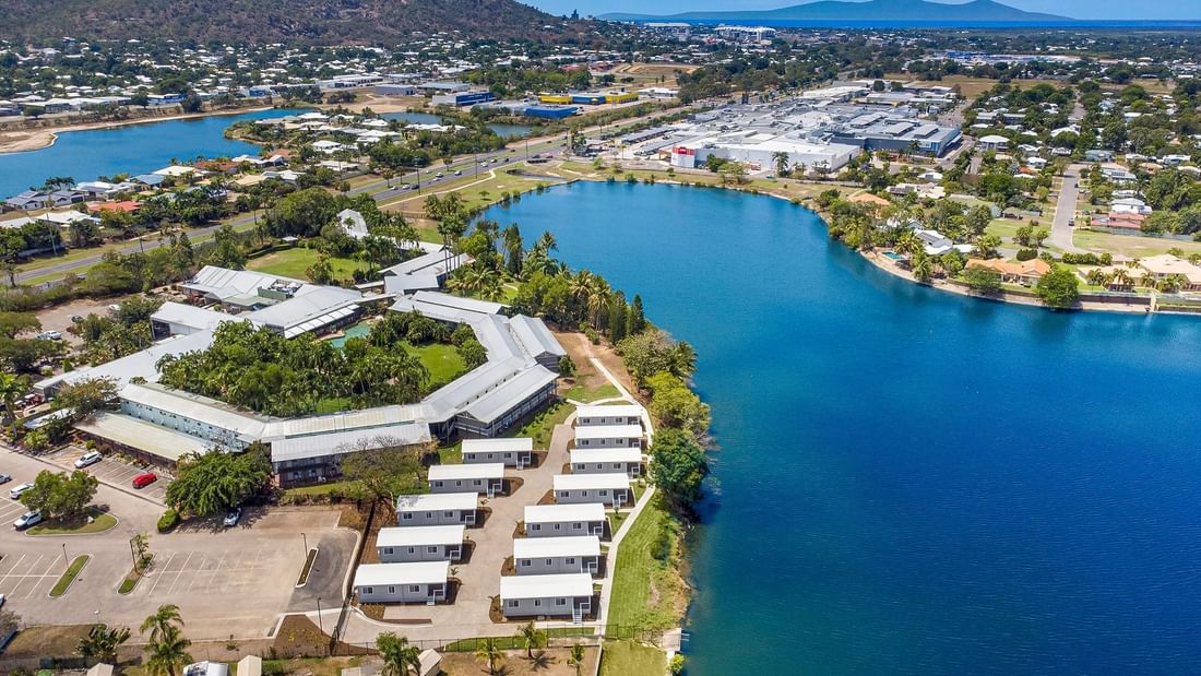 Aerial view of Deluxe Bungalow 2 Bedroom featuring palm trees, with a mountain backdrop at Mercure Hotel Townsville