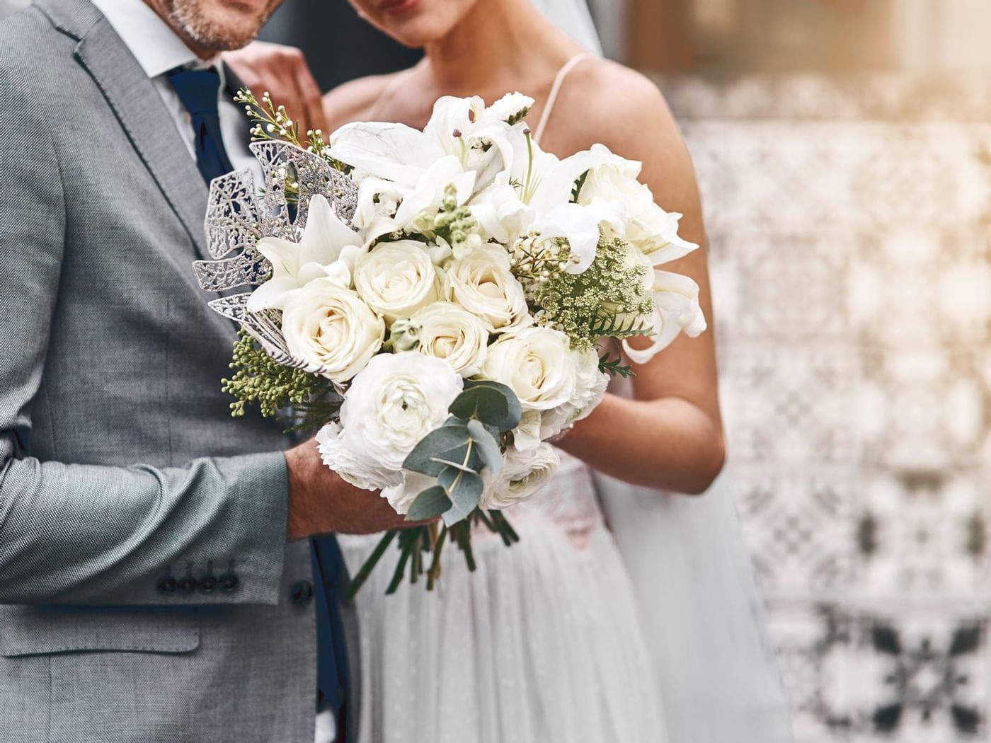 Close-up of wedded couple with flower bouquet at Grand Fiesta Americana