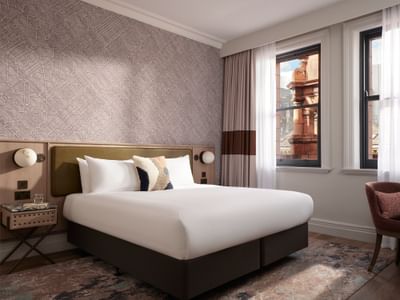 Stylish Premium Double Room at The Met Hotel Leeds, England, with a cosy bed, bedside lamps, and architectural views