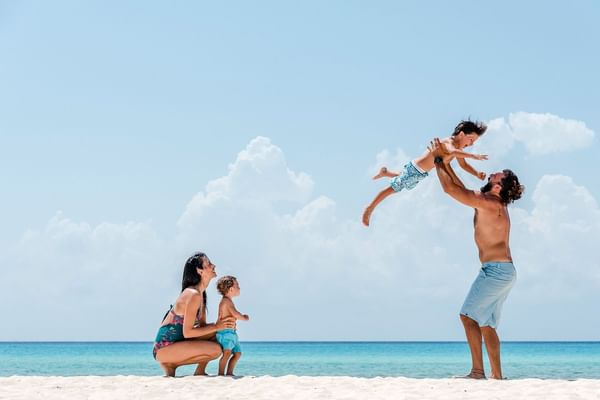 A family playing on beach at The Reef Playacar