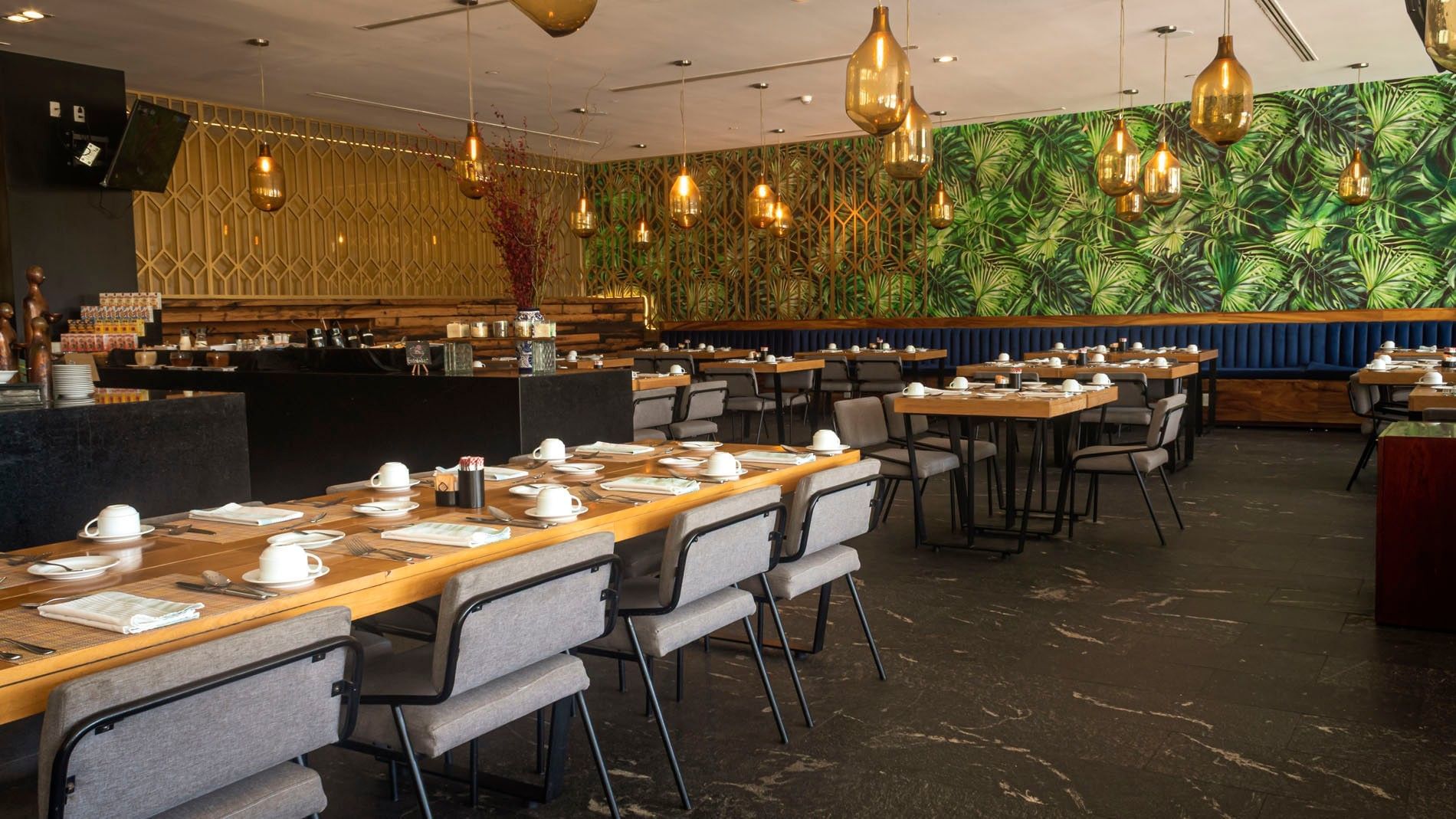 La Huerta dining room featuring tropical leaf wallpaper and gold pendant lights at Camino Real Puebla Angelopolis