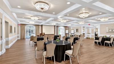 Towpath Ballroom set with tablecloths on round tables and coffered ceilings with chandeliers at Avon Old Farms Hotel