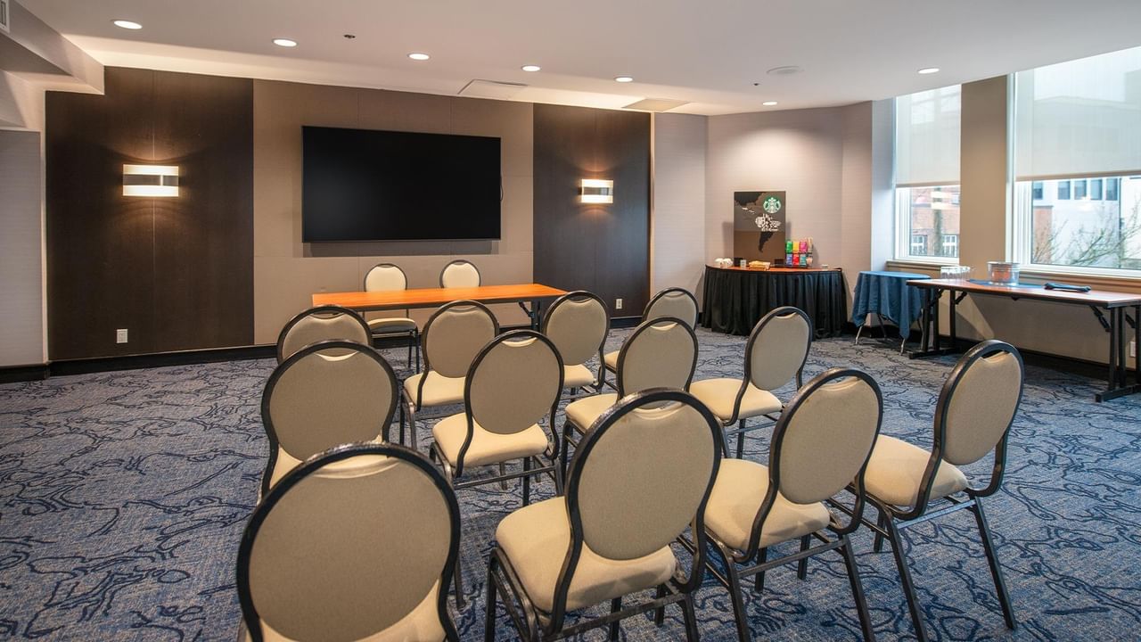 Empty meeting room with chairs and tables at Coast Bastion Hotel.