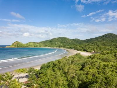 Vista aérea de la bahía en forma de media luna y el frondoso bosque de Morgan's Rock Reserve & Ecolodge, uno de los hoteles de San Juan del Sur.