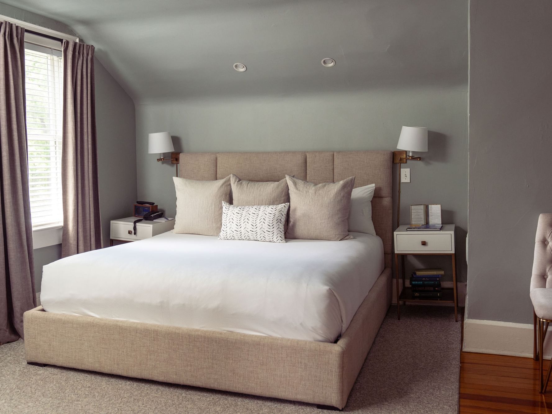 Peony room at The Clifton in Charlottesville with large bed, two nightstands, and a chair.