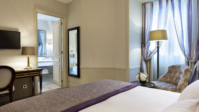 Executive room with bed and doors open to the bathroom at Hôtel Westminster - Paris