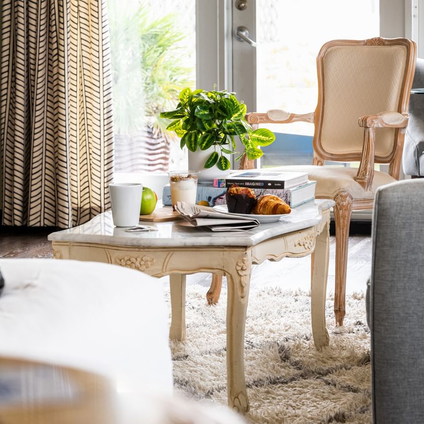 Elegant marble coffee table with breakfast and books in a bright, stylishly curated room at Riviera Hotel South Beach