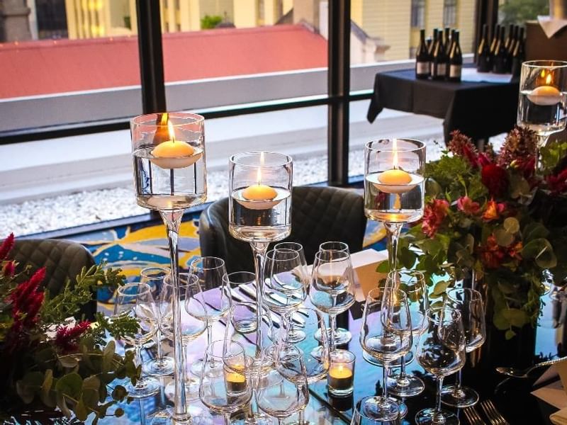 Dining table setup with candles, glassware, and a floral centerpiece in Prive at Sofitel Brisbane Central