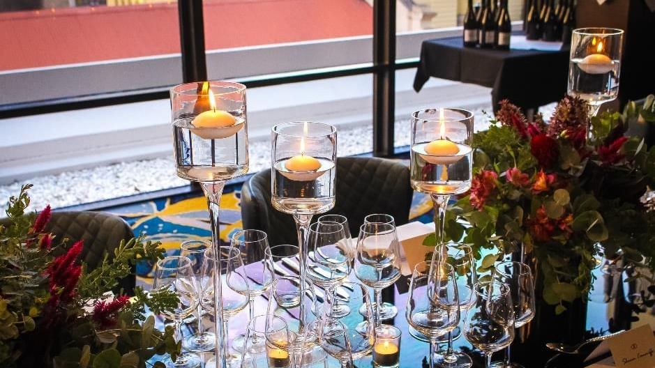 Table setting with stacked wine glasses and floating candles in Privé at Sofitel Brisbane Central