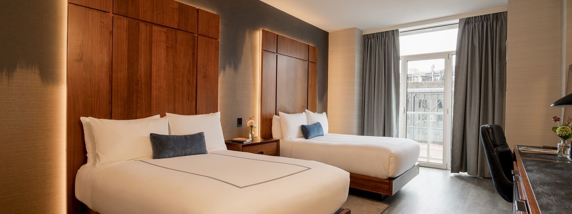 Deluxe Double Room with wooden beds, pillows, and a large window at Gansevoort Meatpacking NYC in New York.