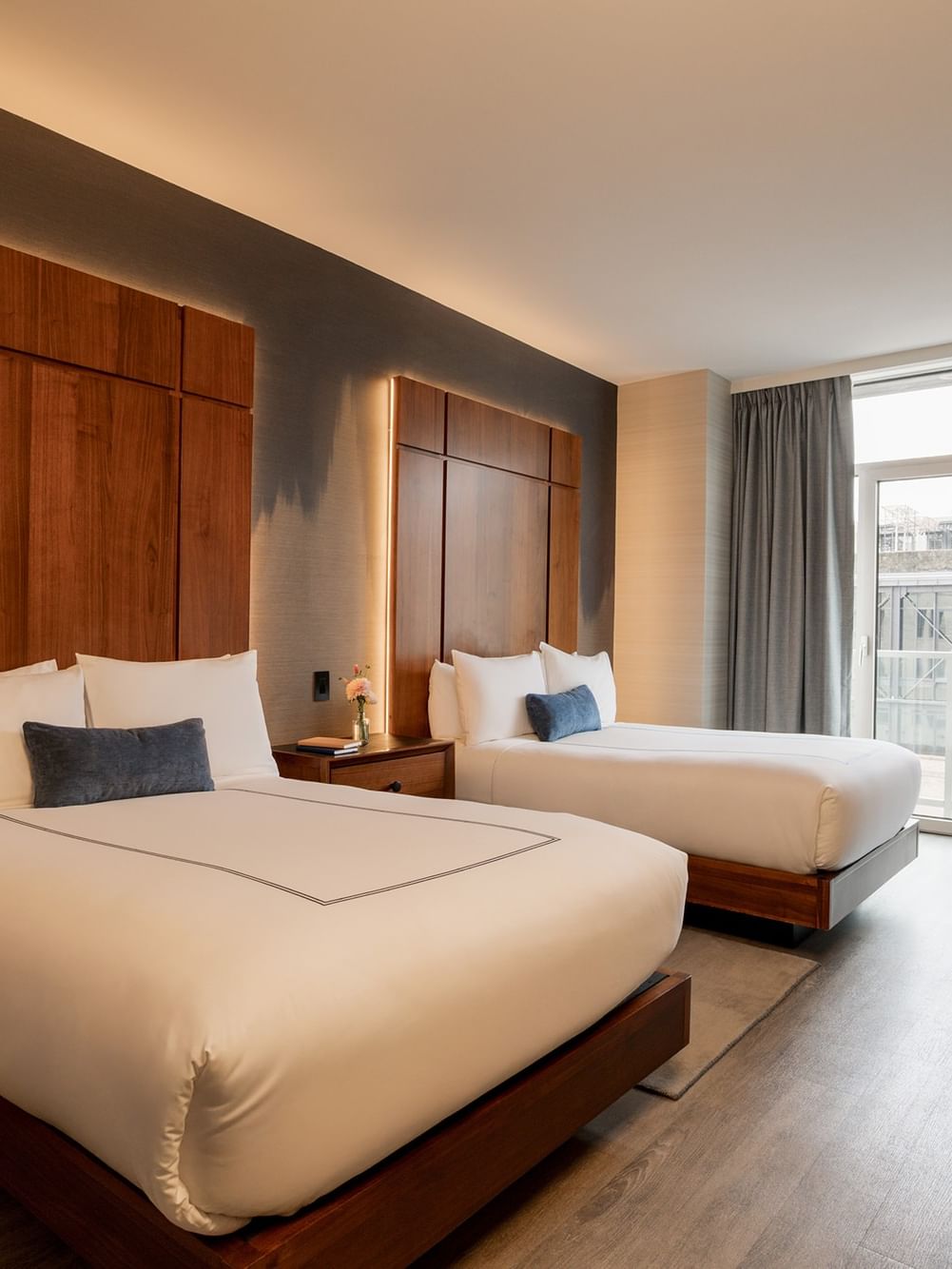 Deluxe Double Room with two beds, backlit wood headboards, and city views at Gansevoort Meatpacking NYC - NEW