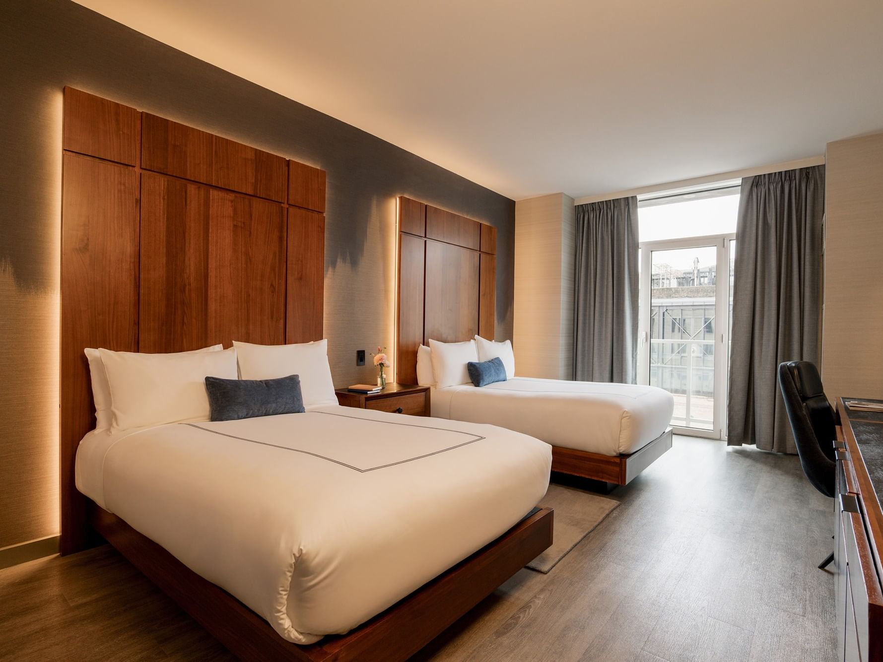 Deluxe Double Room with wooden beds, pillows, and a large window at Gansevoort Meatpacking NYC in New York.