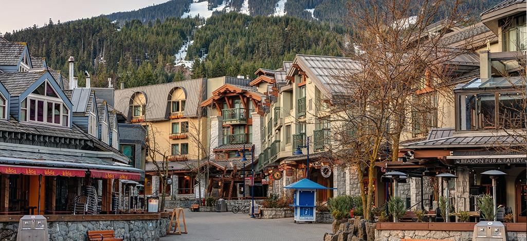 Whistler Village Stroll with snow-covered ski runs in the distance