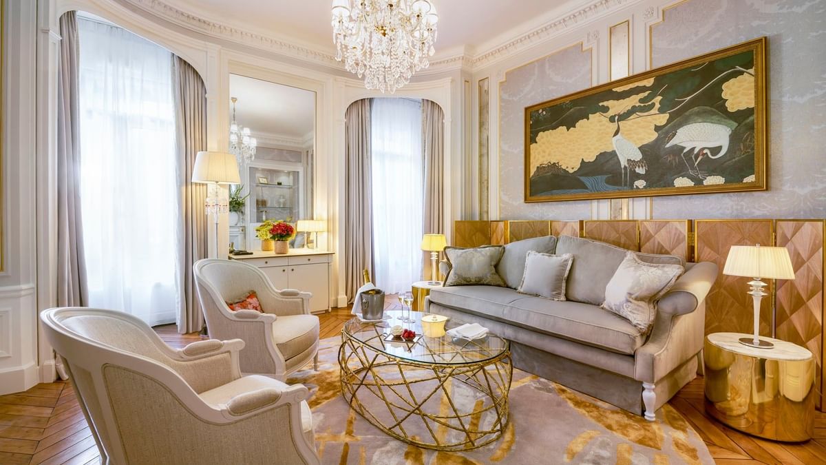 Lounge with sofa placed by a glass table under a crystal chandelier in Duke of Westminster Suite at Hotel Westminster Paris