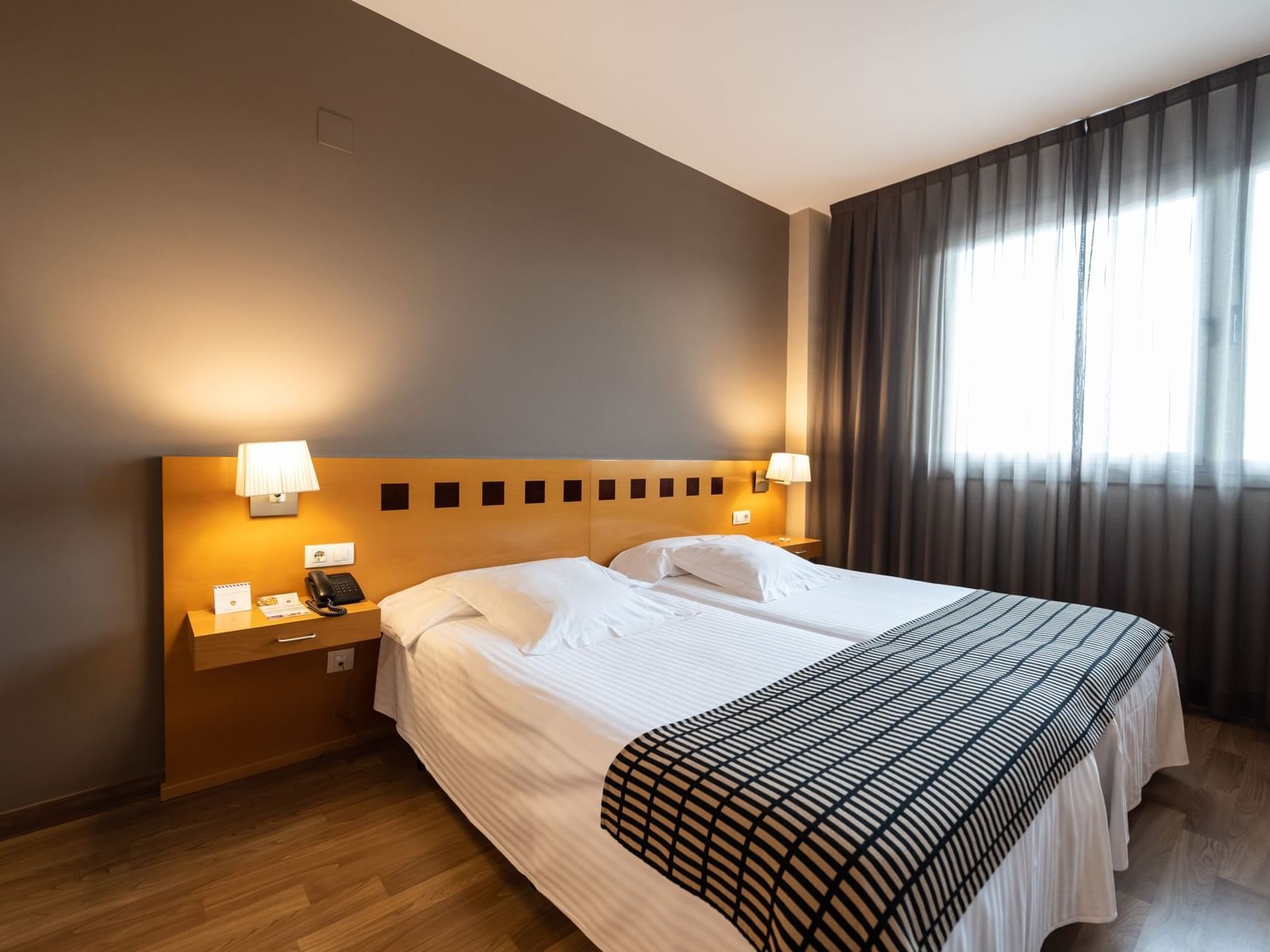 Twin beds, bedside lamps & windows with curtains in Superior Double Room at Hotel Vila Centric