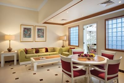 Living room with sofa & round table with chairs at Hotel Ajman