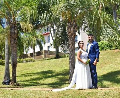 Recién casados posando cerca de un árbol en Panoramic Grand