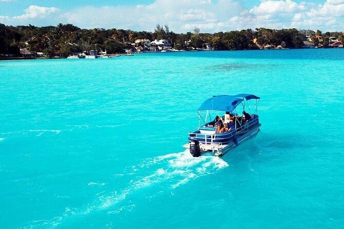 Boat cruising across vivid turquoise water on Bacalar Lagoon in Quintana Roo, Mexico.