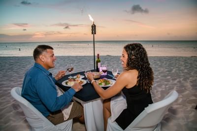 A couple having dinner by the beach at Amsterdam Manor Resort