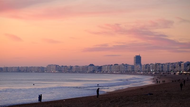 Aerial view of beach and town at dawn near Oceania Hotels